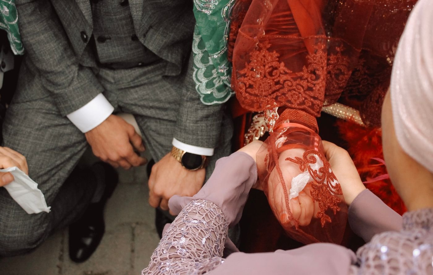 Henna wordt aangebracht bij de bruid tijdens een kına gecesi, met rode sluier en kant