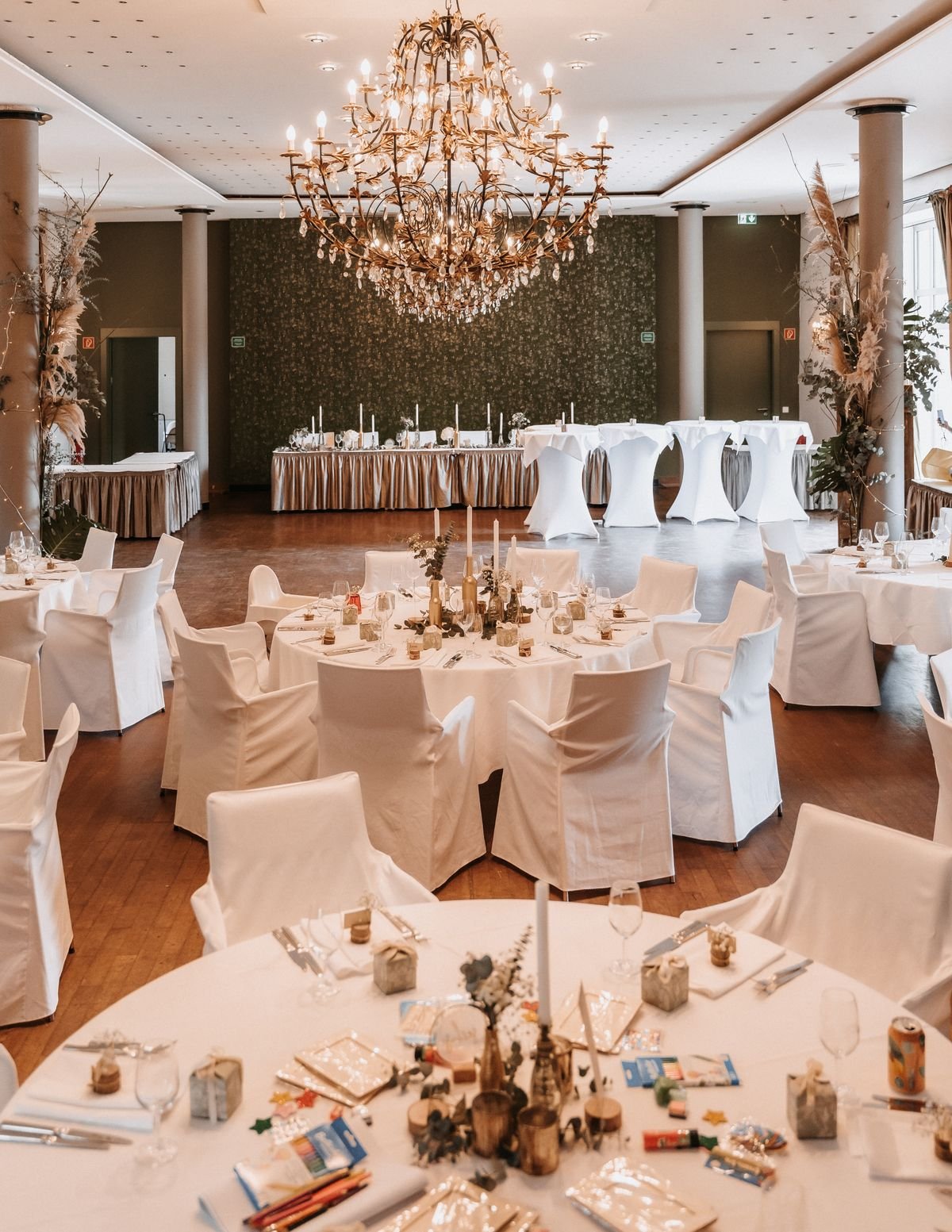 De kleine turkse feestzaal met ronde gedekte tafels en een kroonluchter
