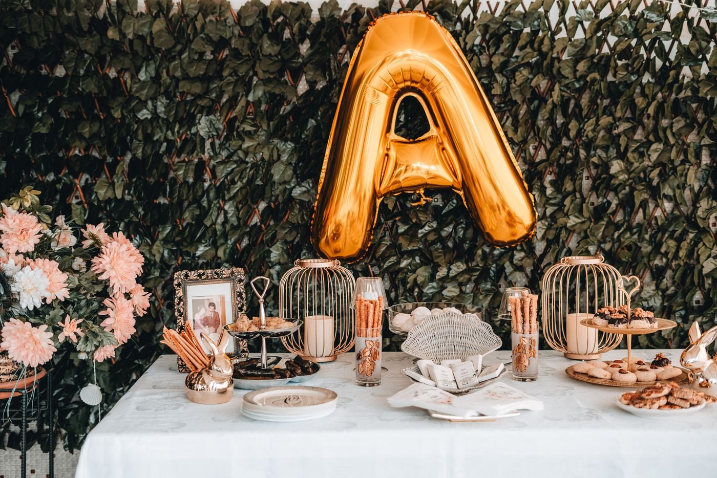Zoete tafel met koekjes, gebak en een gouden ballon voor een besnijdenisfeest